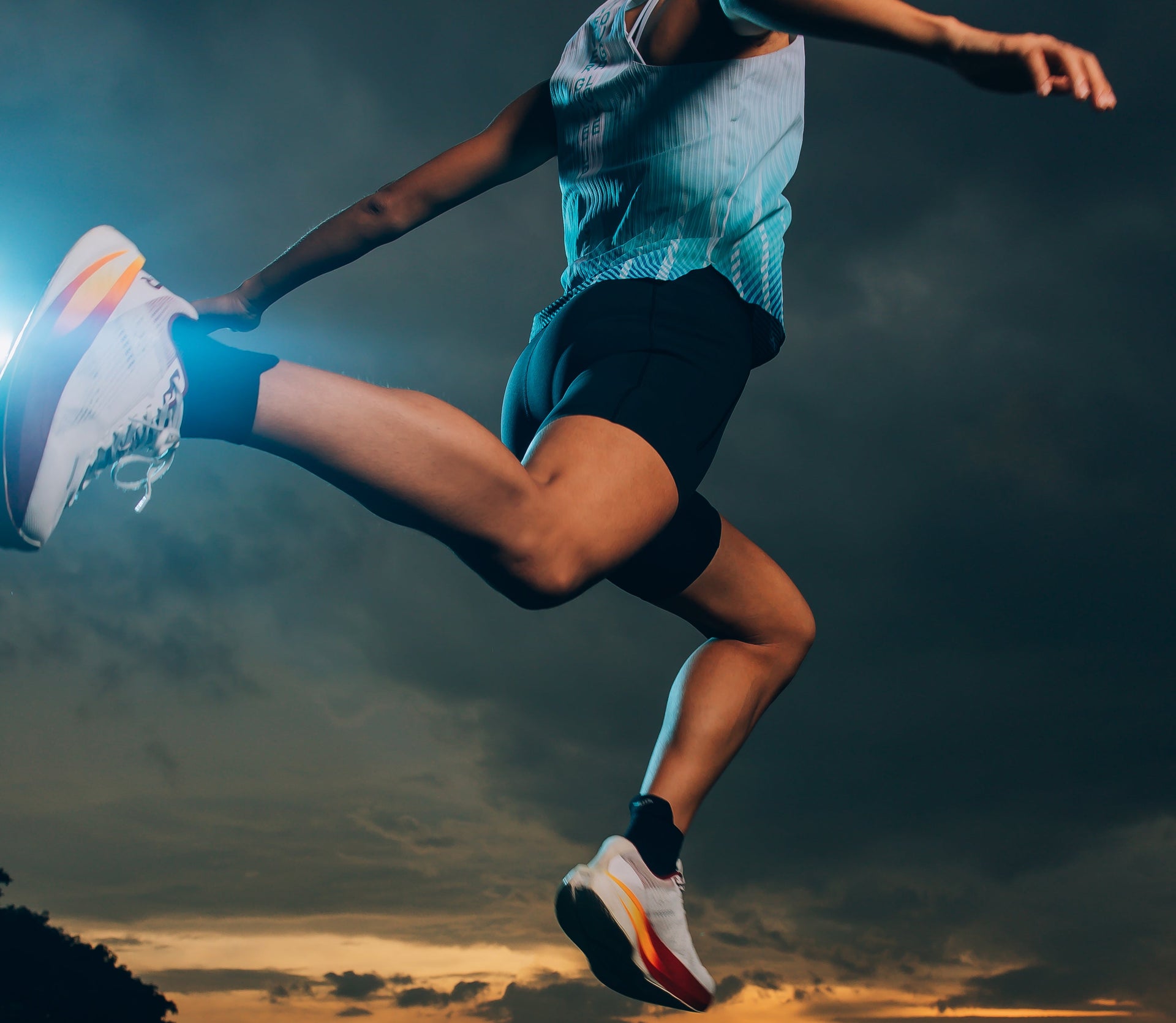 Person running on a road with a sunset sky